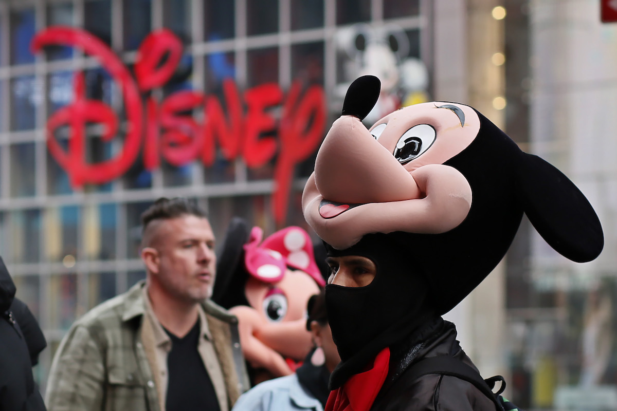 Un uomo vestito da Topolino a Times Square, New York: la Disney ha annunciato migliaia di licenziamenti