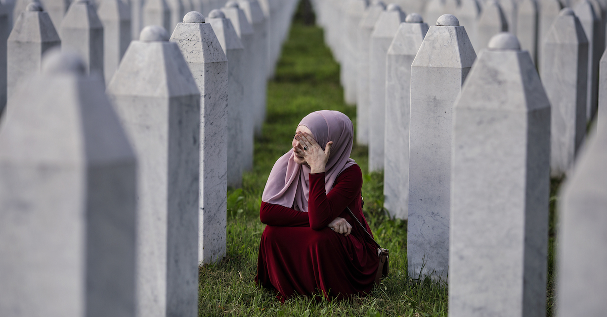 Una donna bosniaca piange sulle tombe di suo padre, i suoi nonni e gli altri familiari, tutti vittime del massacro di Srebrenica del 1995 al cimitero di Potocari nel 25esimo anniversario (2010)