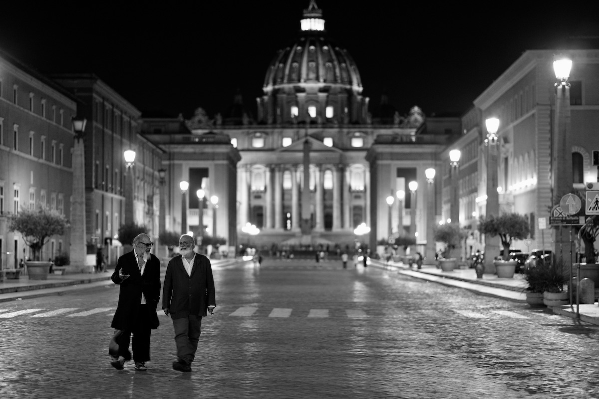Roma, Santa e Dannata: Roberto D'Agostino e Marco Giusti, registi e protagonisti del documentario, camminano su Via della Conciliazione