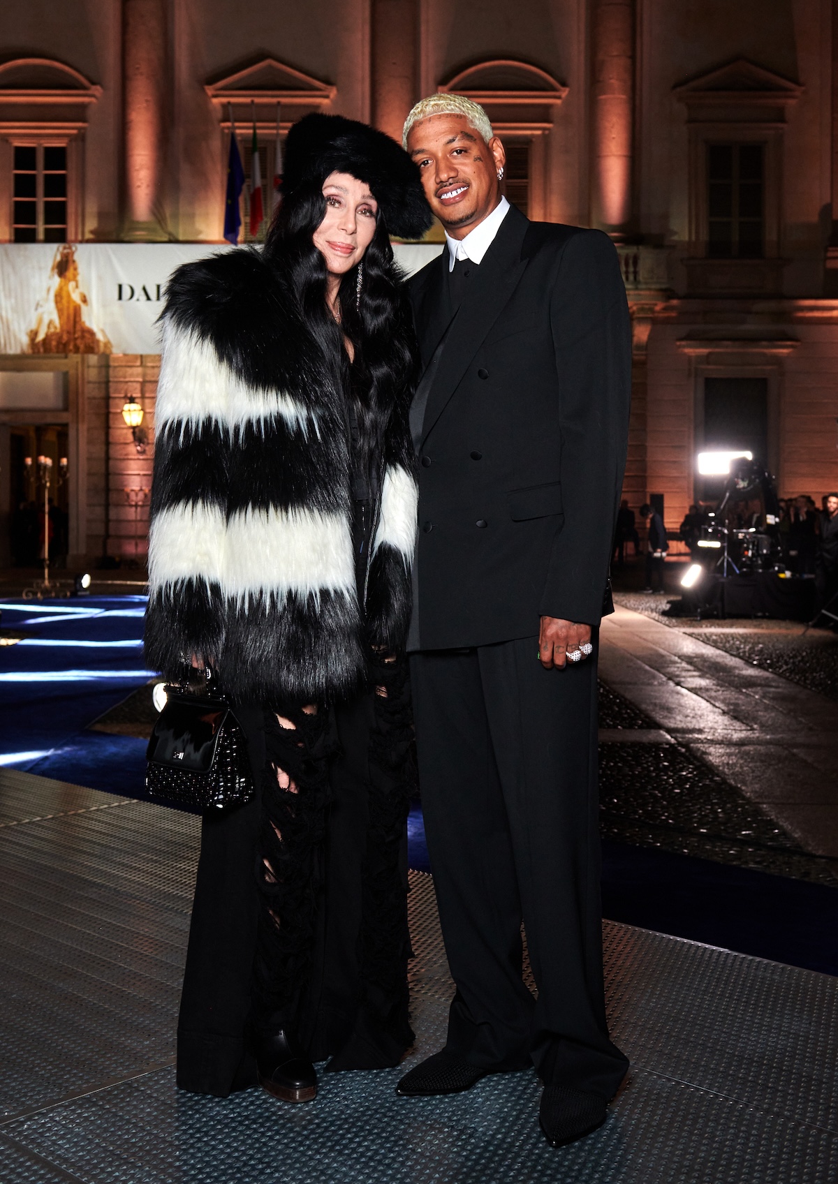 Cher e Alexander Edwards davanti al Palazzo Reale di Milano per la mostra Dal cuore alla mani - Dolce&Gabbana